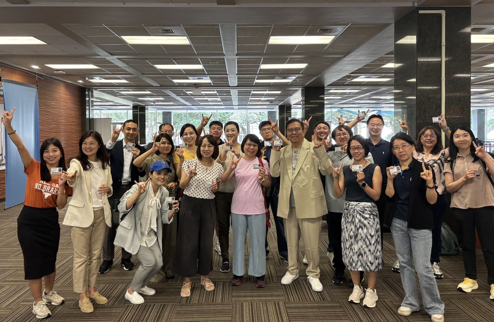 參與移地訓練教師手持德州大學奧斯汀分校的學生證合影。此課程賦予學員使用豐富資源，包含實體圖書館與線上文獻借閱及下載，校園設施使用，以及市區大眾運輸工具搭乘。讓參與培訓的教師在精進EMI教學實踐技巧之餘，能利用圖書館、線上文獻和交通等資源，獲得深度的跨文化學習體驗，豐富對EMI教學多樣性的理解。